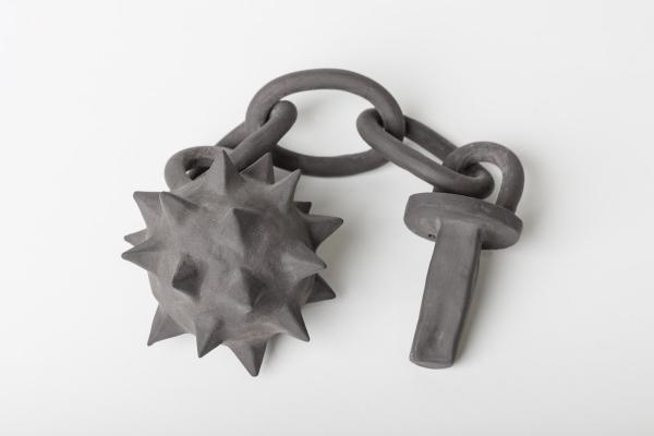 A spiked mace on a chain with handle, all made from grey, chunky ceramic. By Kate McDonald