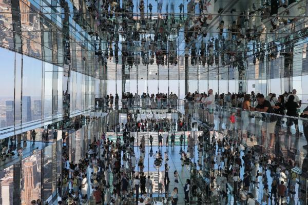 Reflections by Dave Clegg shows a very crisp photograph of the interior of a multistory glass and mirror buidling filled with people