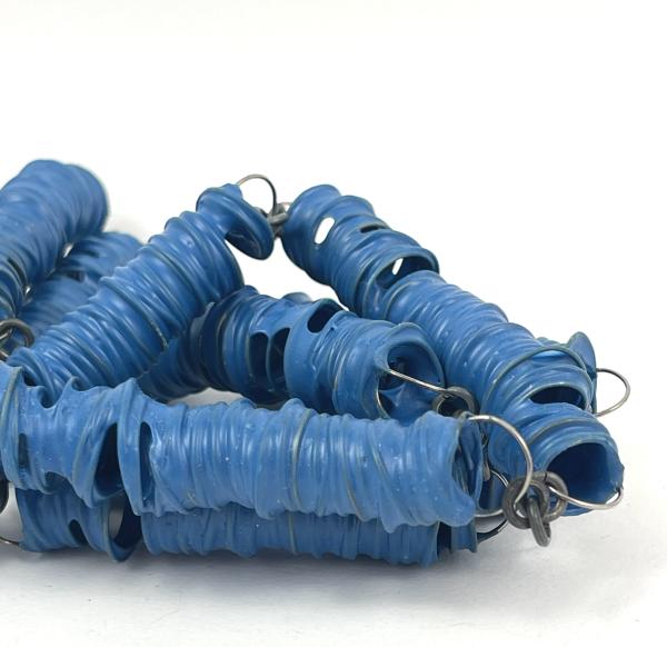 Metal coils are encased in a blue plastic coating. A work by Phillipa Gee