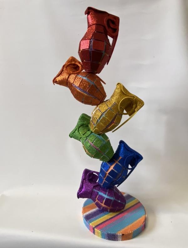Small scupture my melanie Fleet. A stack of rainbow grenades. Each grenade made from reused fabric and card.