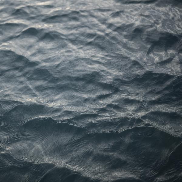 Photographic/still image artwork by Amber Jayne-Bain. Rippling water fills the image. Dark rocky blue and opaque, the surface gives few clues as to the scale or type of body of water it shows.