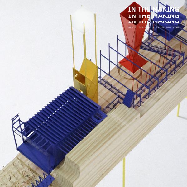 Architectural model by Tom Arbuckle. Geometric structures and walk ways in bold primary colours sprawl down a pine wood platform.