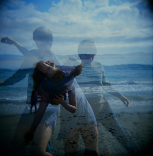 Jake & Anita. Faded and blurred slide image of a beach. Multiple transparent figures in motion.